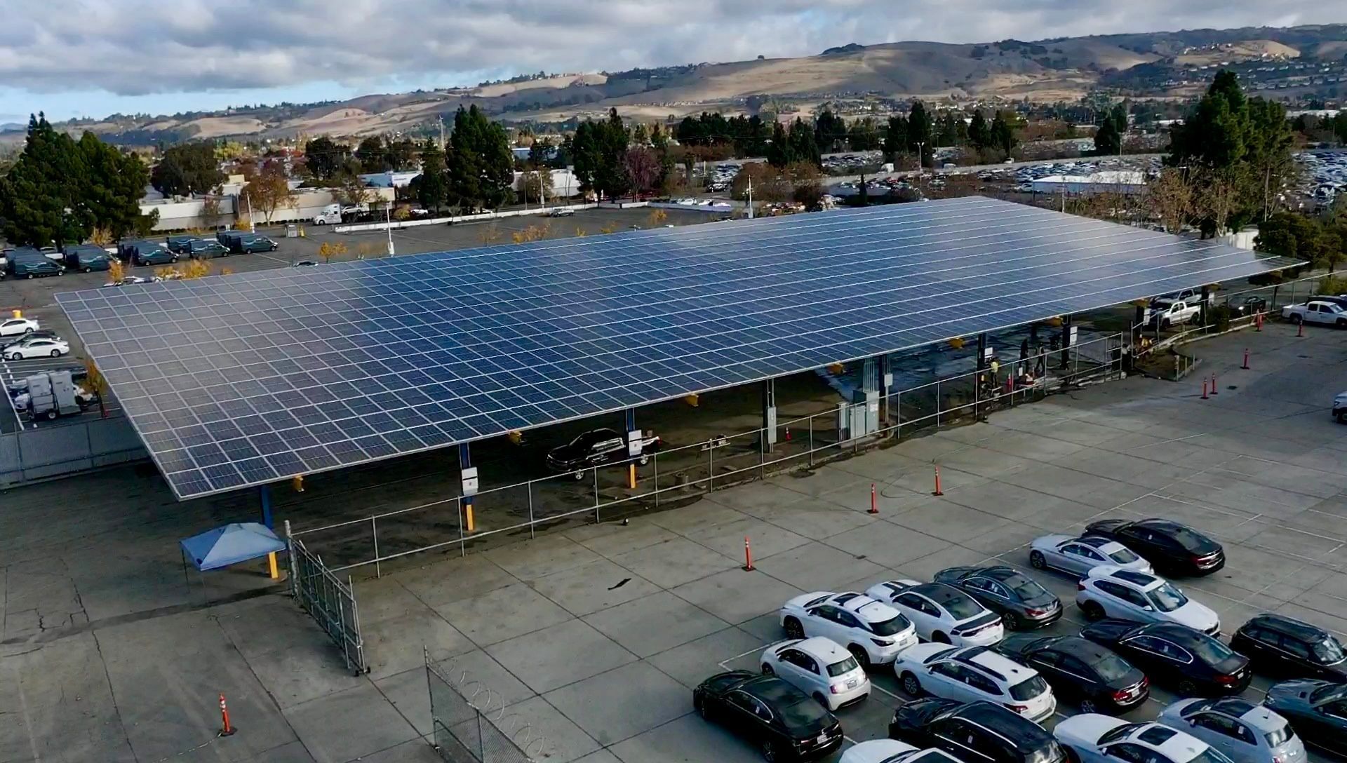 An aerial view of a parking lot with solar panels on the roof.