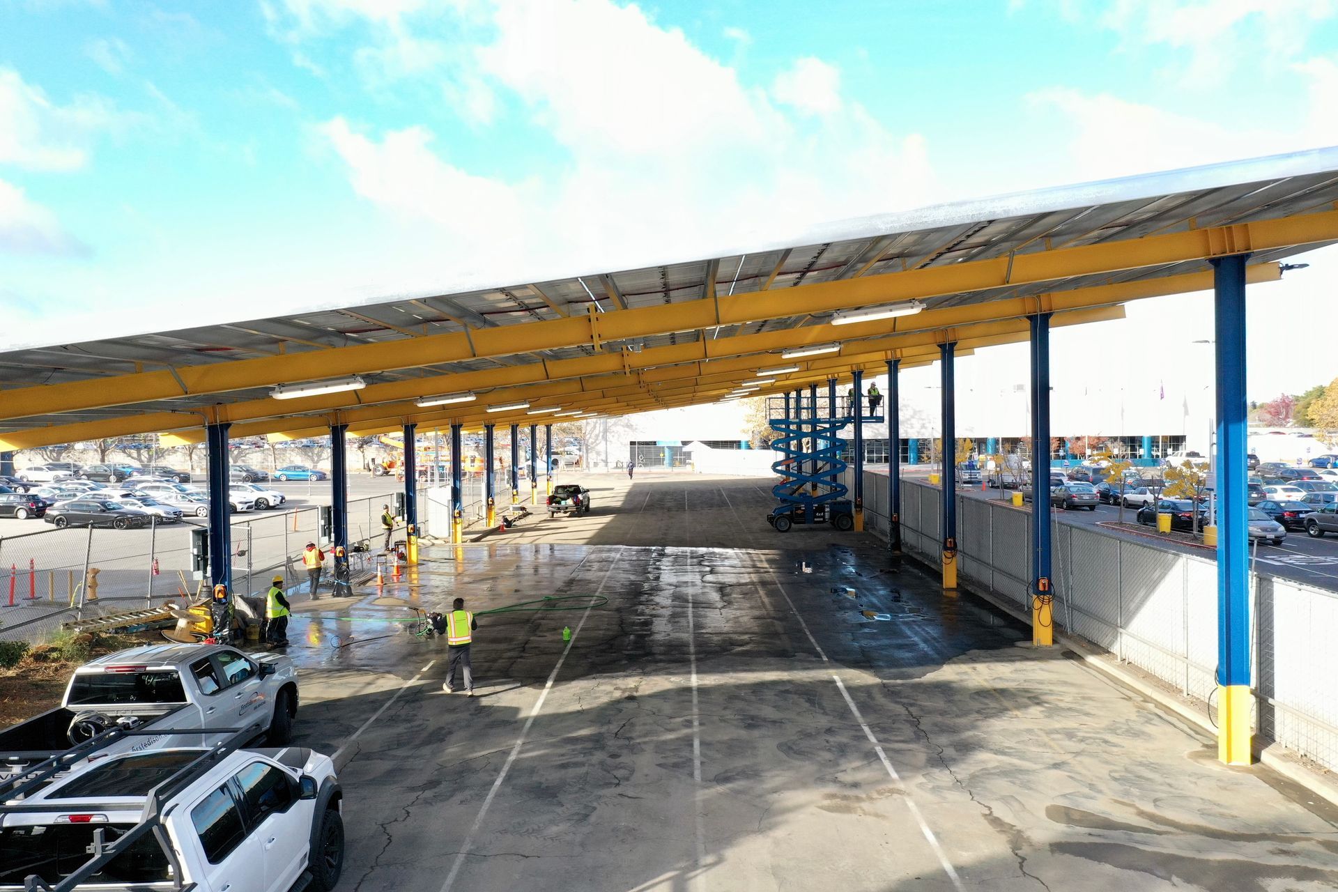 An aerial view of a parking lot with cars parked under a canopy.
