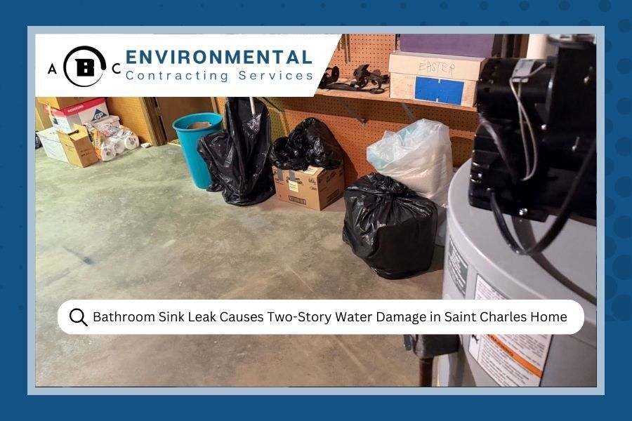 Basement with water damage. Black trash bags, boxes, water heater, and text overlay about water damage from a sink leak.