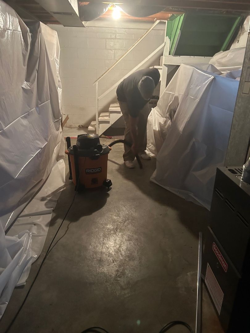 HEPA vacuuming with containment barriers set up in fire-damaged basement