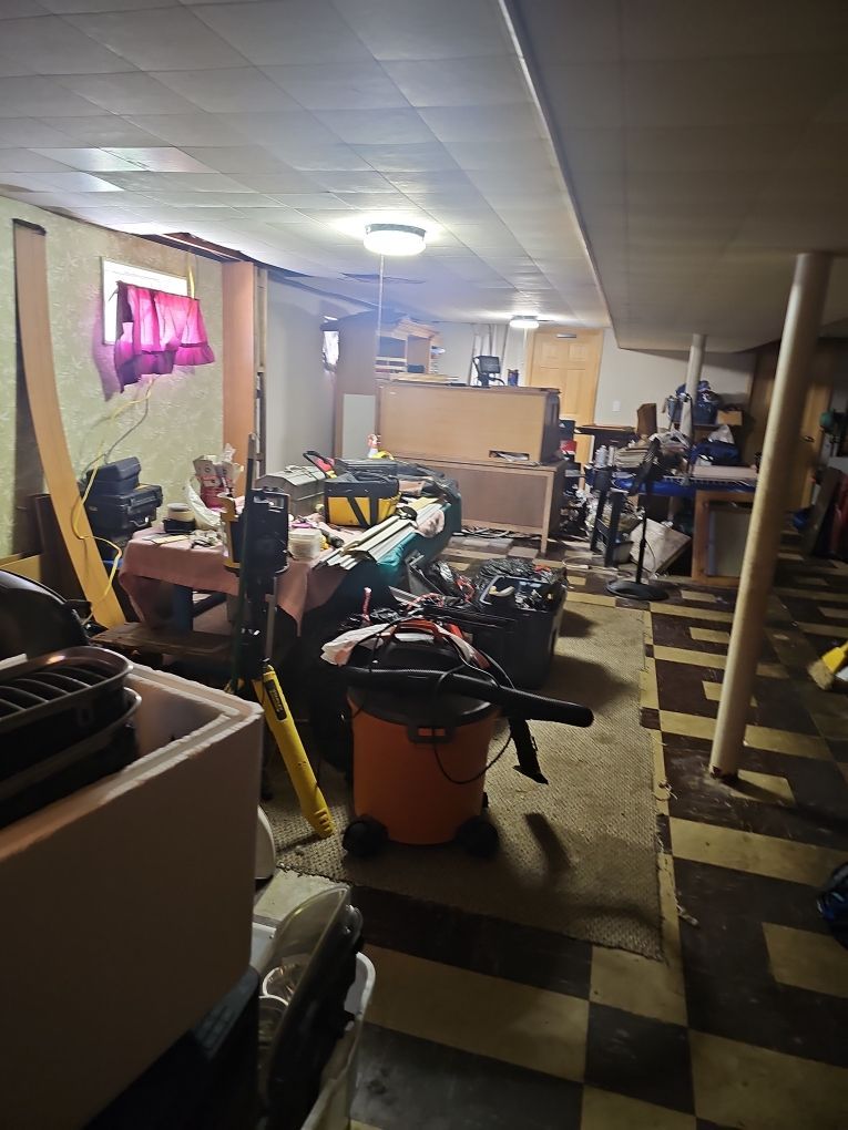 Technician HEPA vacuuming surfaces in a water-damaged basement