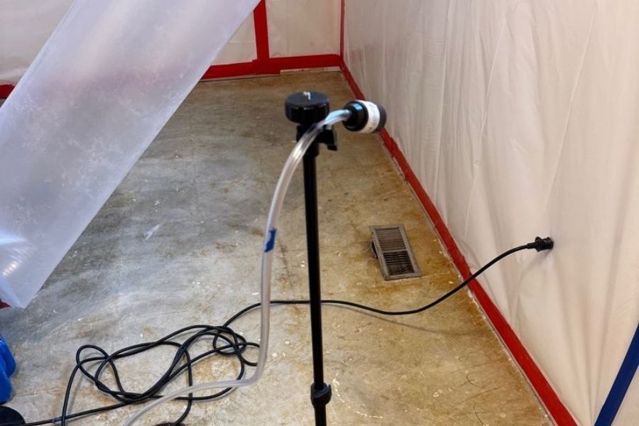 Professional asbestos air testing equipment set up during a residential inspection in St. Louis