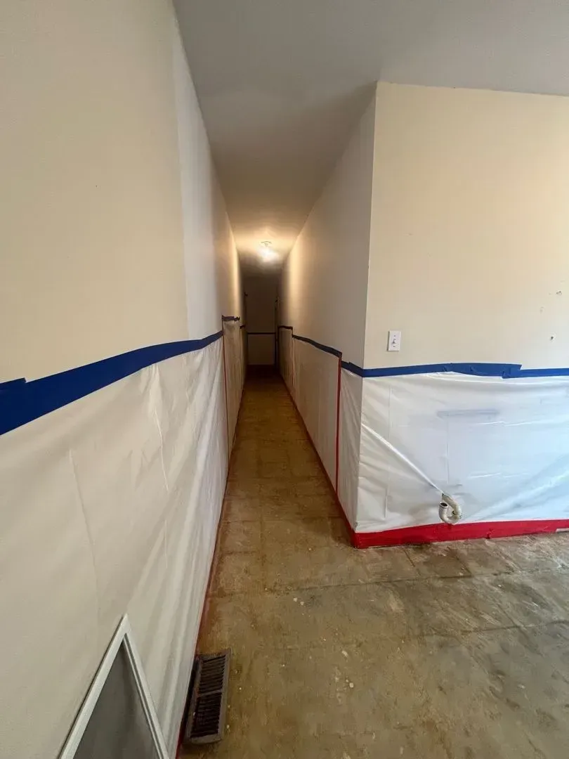 Asbestos containment barrier set up in residential laundry room during abatement