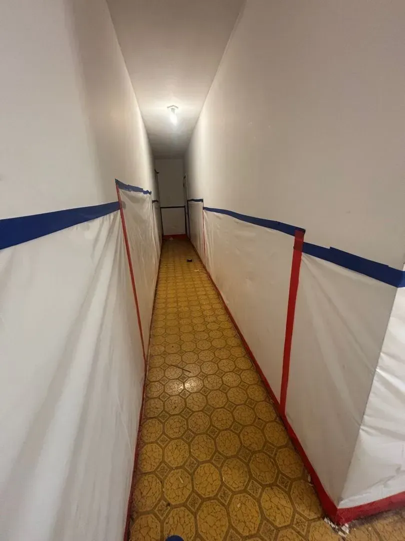 Asbestos abatement containment area with air scrubber equipment visible