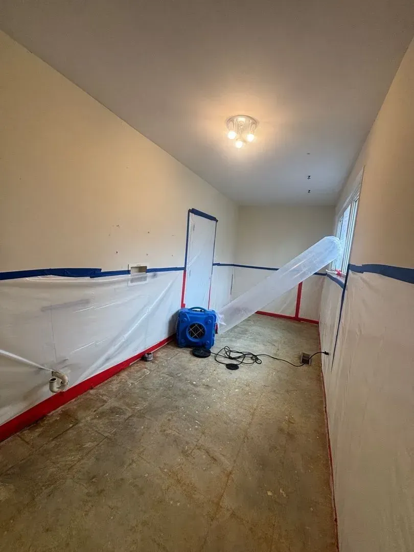 Final stages of asbestos containment and removal in residential laundry room
