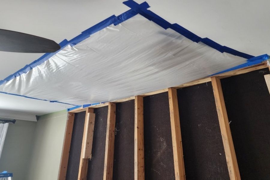 Ceiling containment and drywall removal during water damage restoration in a multi-unit building
