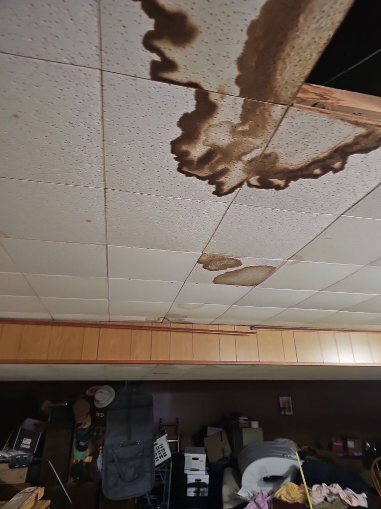 Water-stained and sagging basement ceiling caused by a leak above