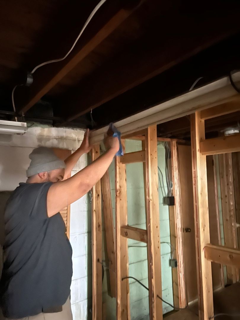 Technician hand-cleaning smoke and soot residue from surfaces after fire damage
