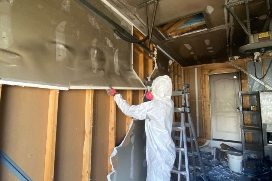 Demolition in progress during fire damage restoration with crews removing charred materials down to the framing