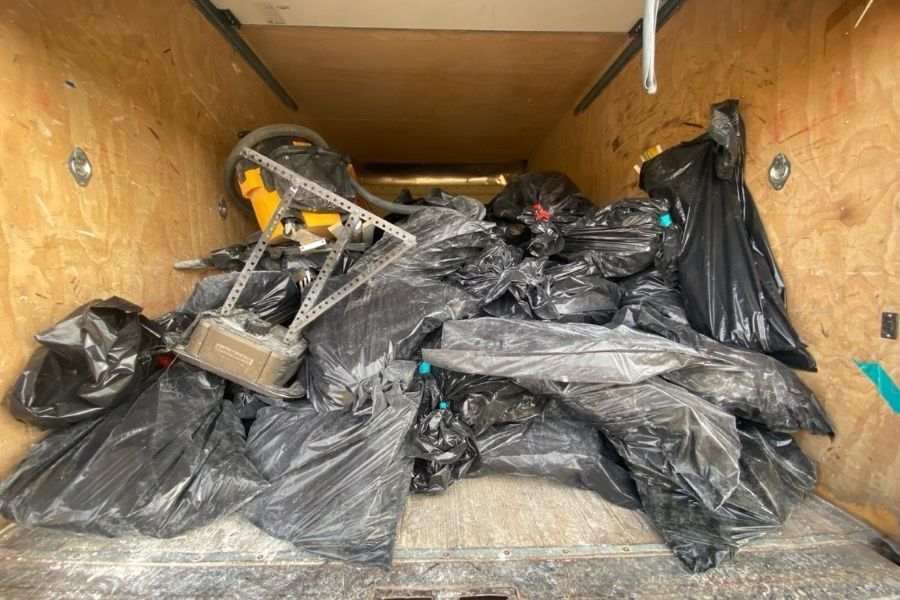 Fire-damaged household items being sorted and removed for disposal during fire cleanup