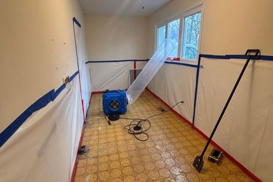 Technicians in protective gear performing professional asbestos removal in a St. Louis County home