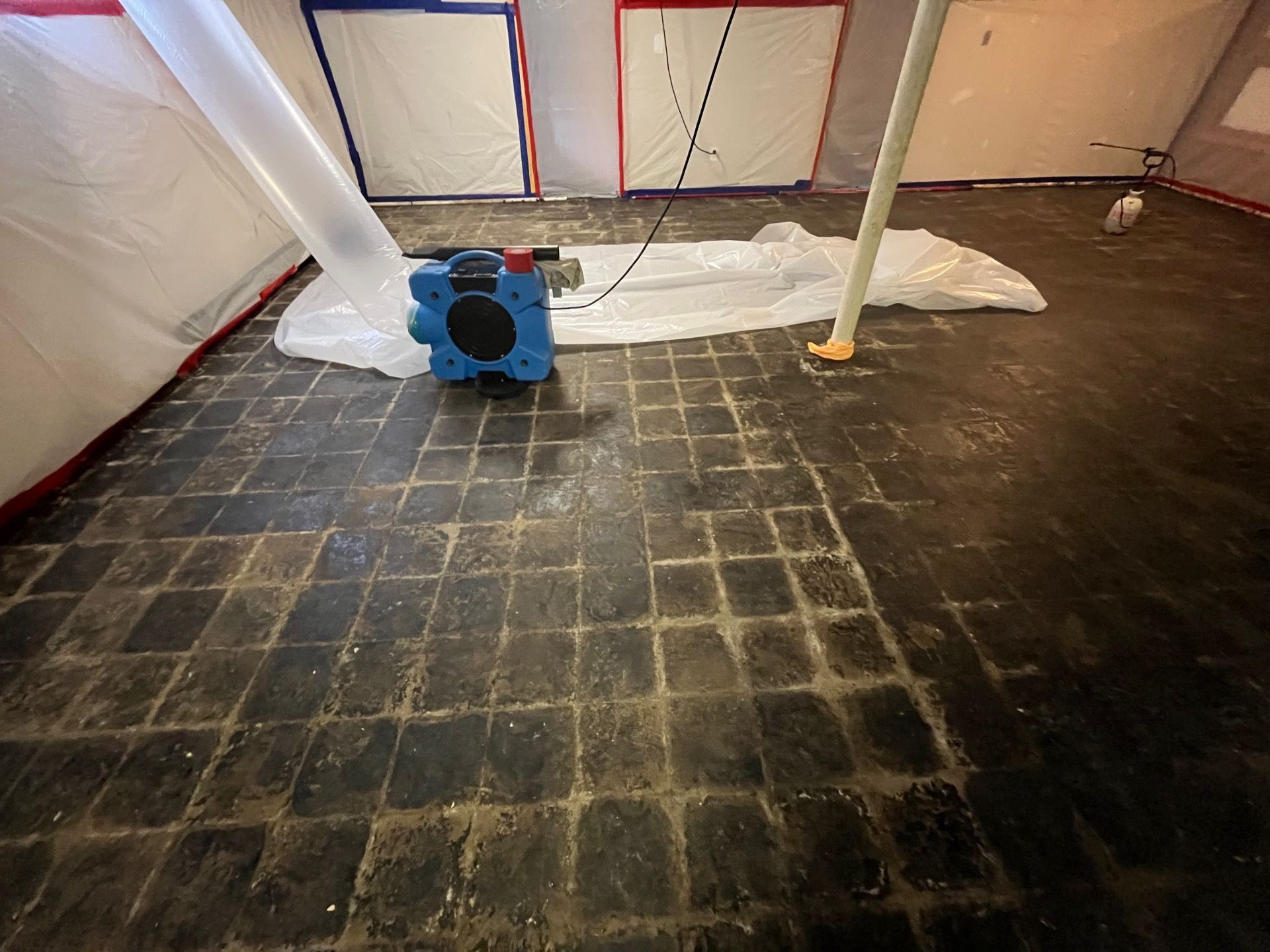 Detailed asbestos removal work in a water-damaged basement space