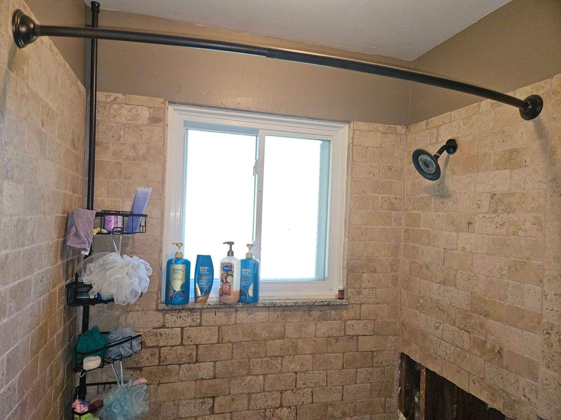 Shower leak water damage staining the base of a bathroom wall