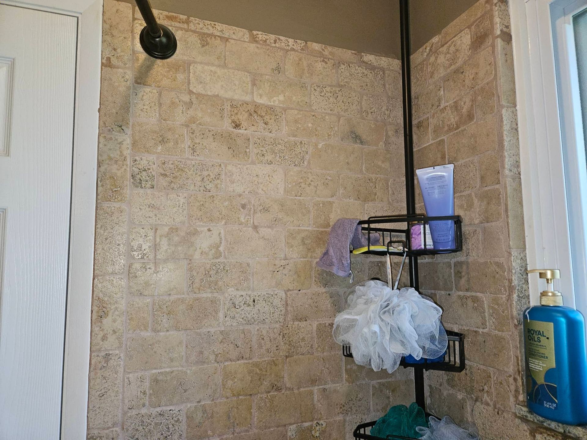 Close view of moisture damage around a residential shower base and floor