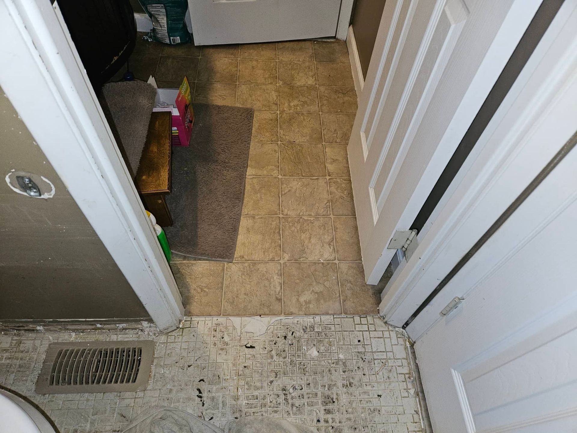 Water-damaged tile flooring lifting near a residential bathroom shower in Maryland Heights MO