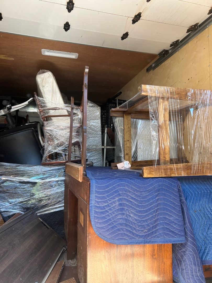 Moving truck packed with furniture wrapped in moving blankets and shrink wrap from the basement