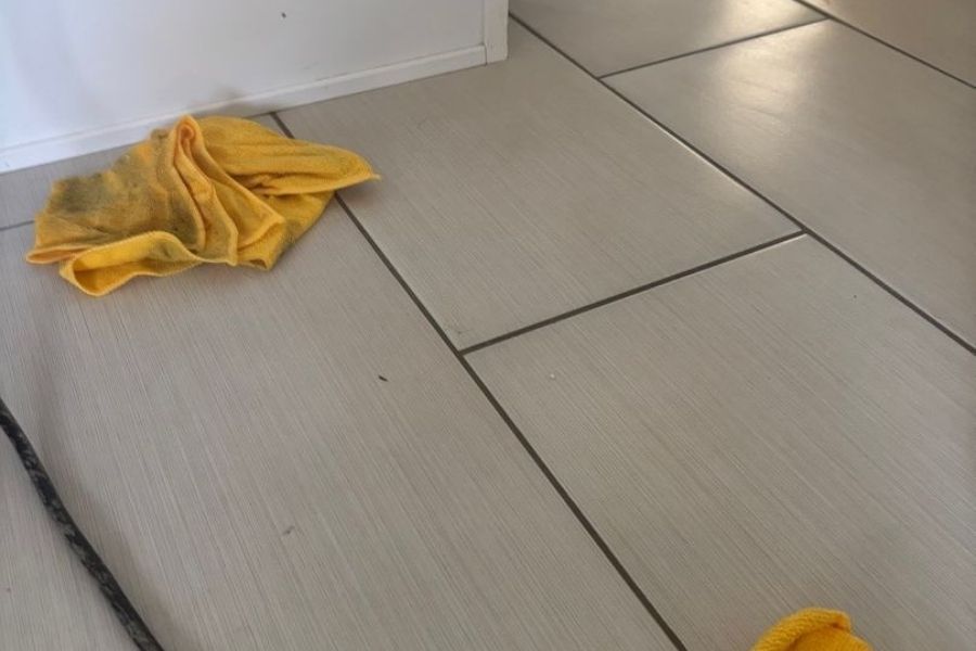 Water trapped beneath tile flooring during a water damage inspection