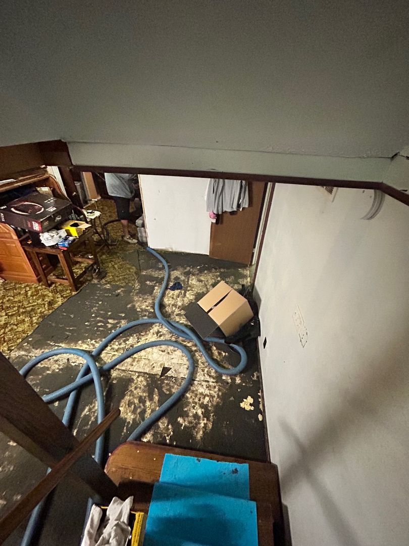 Water extraction equipment running in a residential basement during flood cleanup