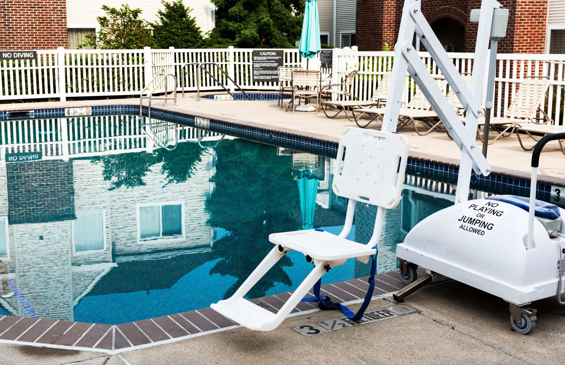 Pool with a white accessibility lift for entering water.