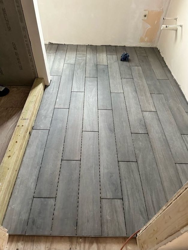 Gray wood-look tiles laid on a floor; a partially finished construction project.