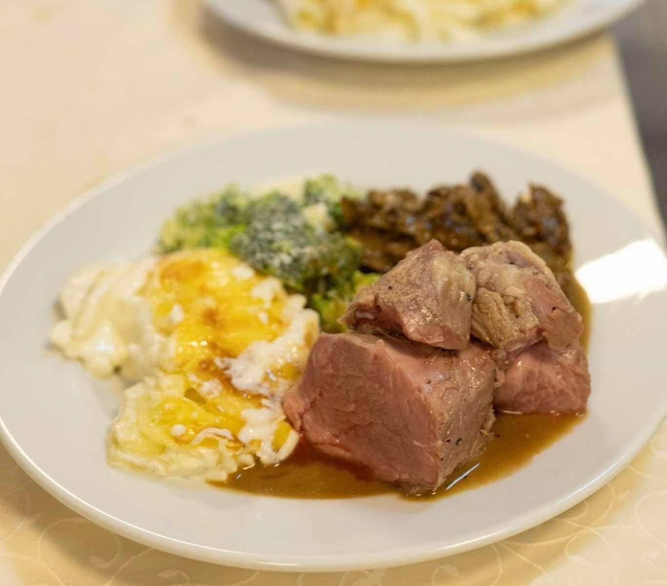 Tallerken med mat: kjøtt, brokkoli, potet og sopp med saus.