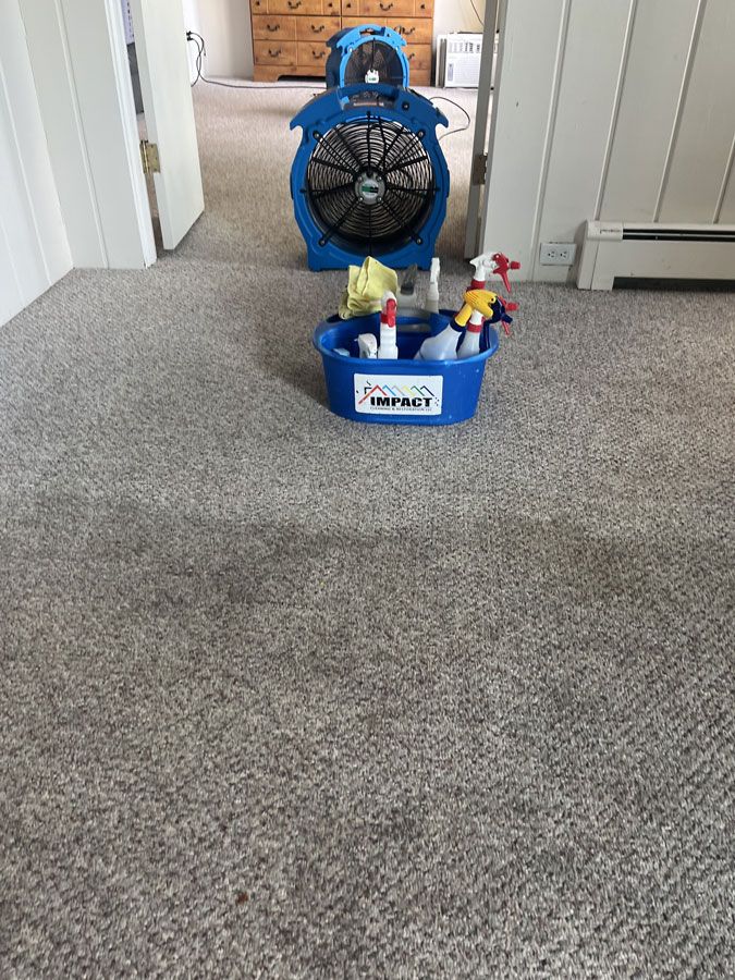 Blue toy fan with small figures on a carpeted floor in a hallway