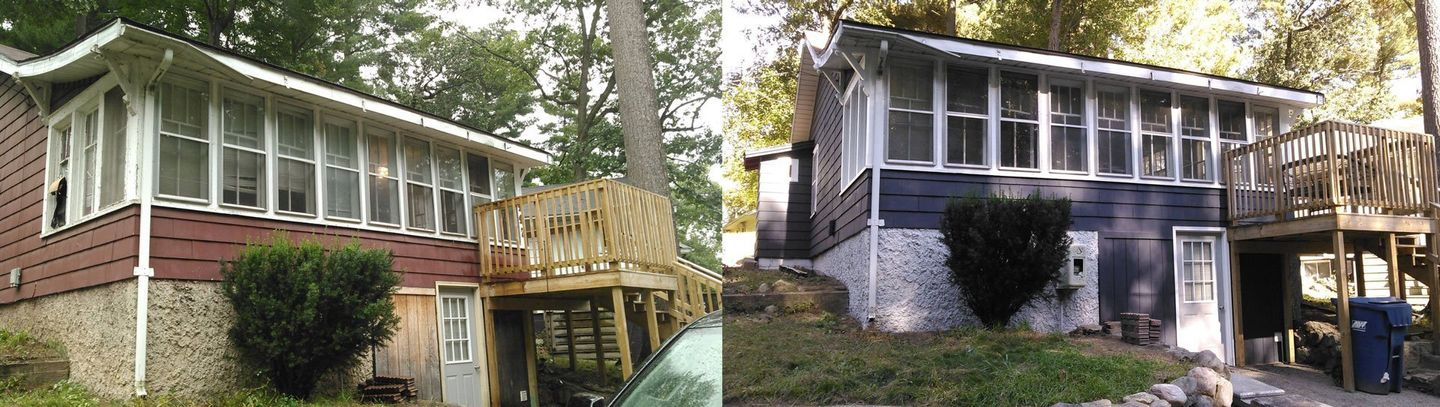 Two houses side by side: one red-brick with a porch, one dark gray with white trim, both partly shaded by trees