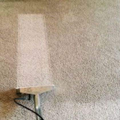 Wall-mounted beige dispenser or box with a dark cable against a speckled wall
