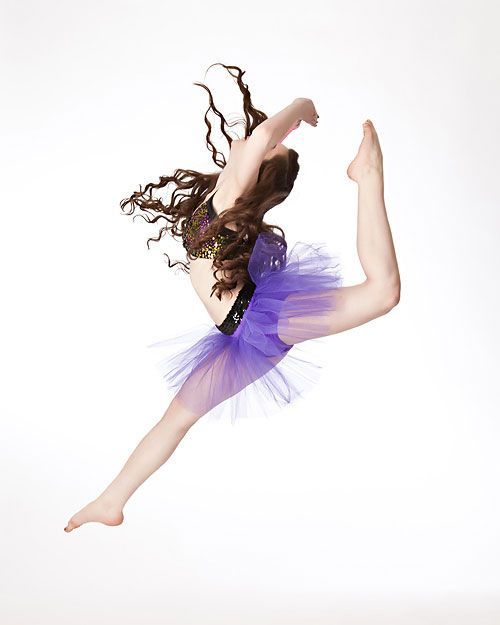Ballet dancer mid-leap in a purple tutu against a white background