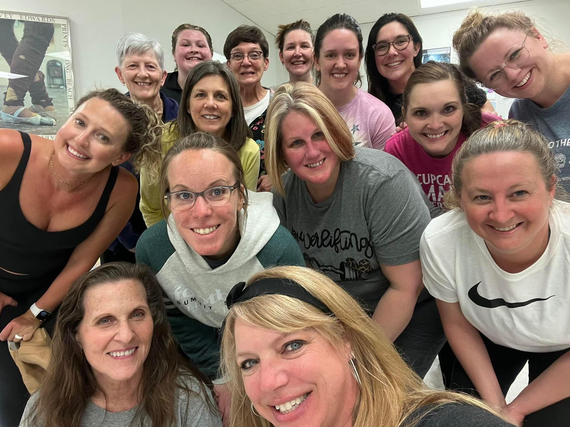 Smiling group of people posing closely together indoors for a selfie