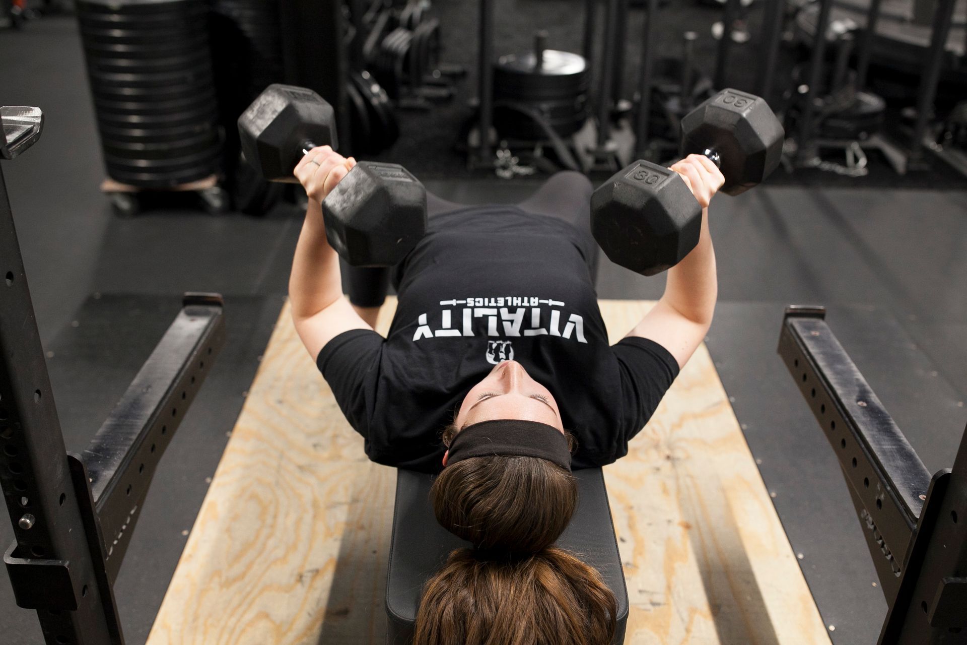 Person doing dumbbell chest press on a weight bench in Vitality Athletics in Ephrata, PA.