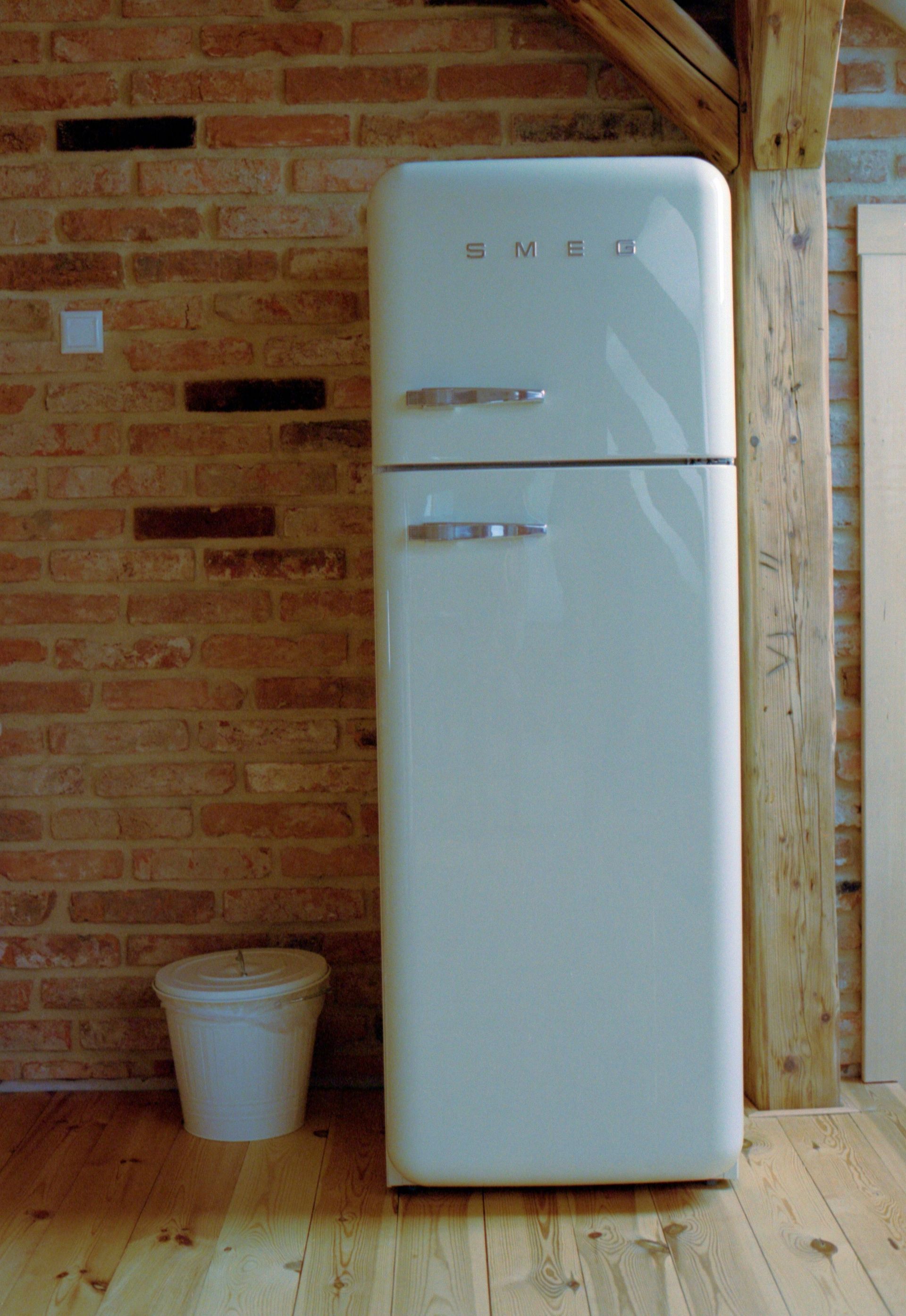 Technician testing a built-in oven with a multimeter in a bright kitchen