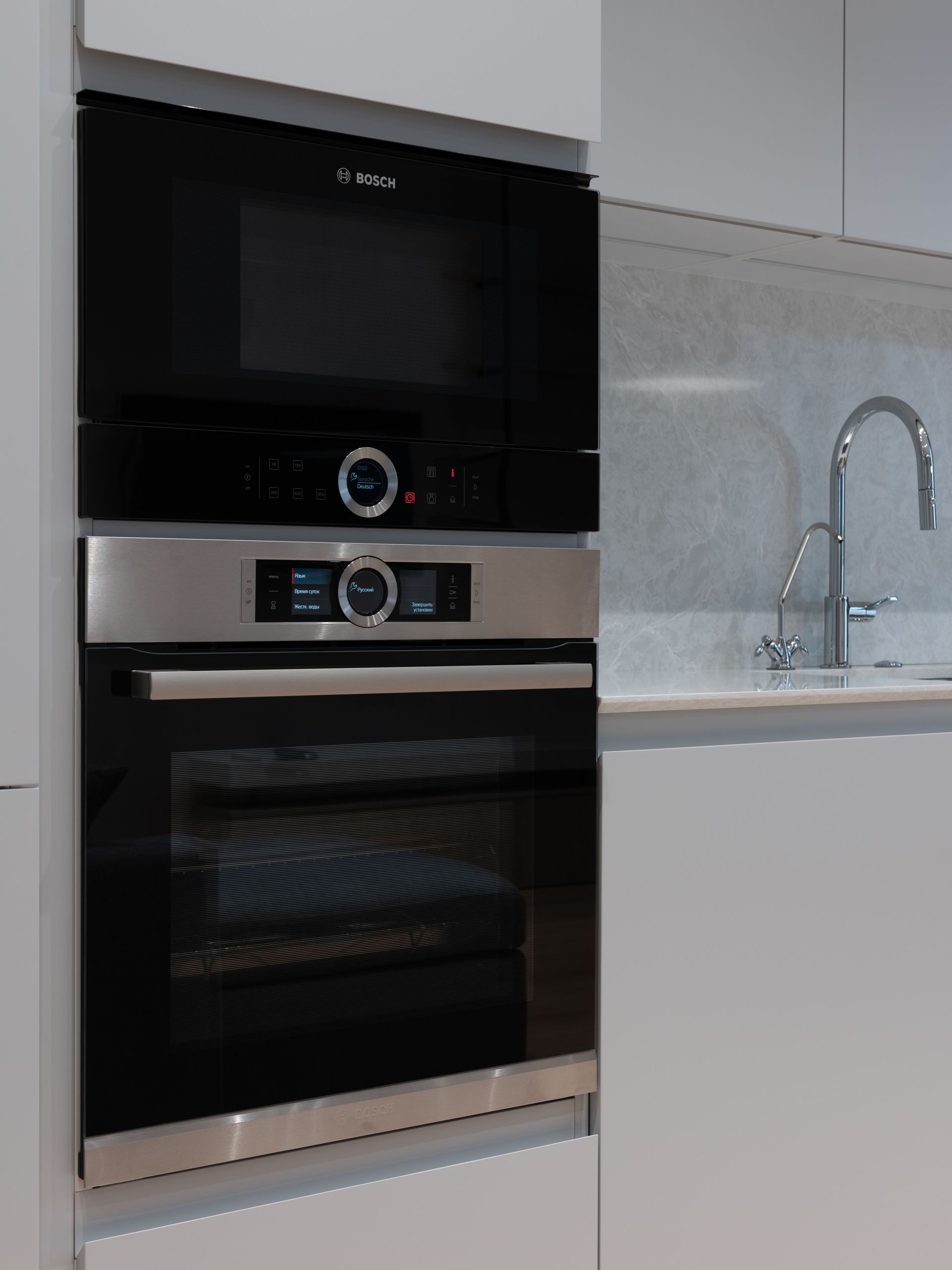 Man inspecting an open oven in a modern kitchen