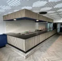Empty modern reception desk with black-and-white striped paneling in a bright lobby