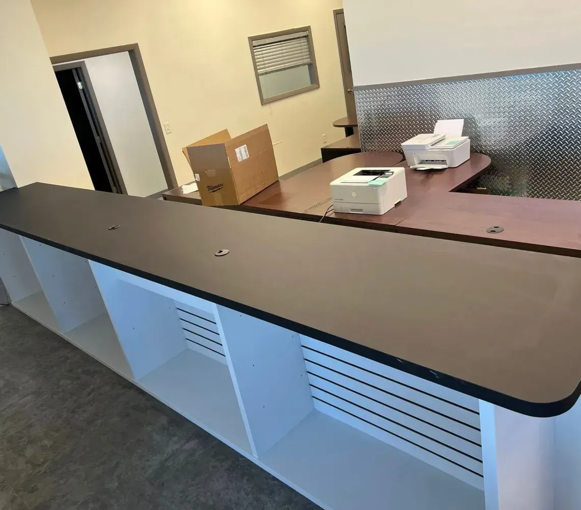 Office reception counter with boxes and a cash register on a beige countertop