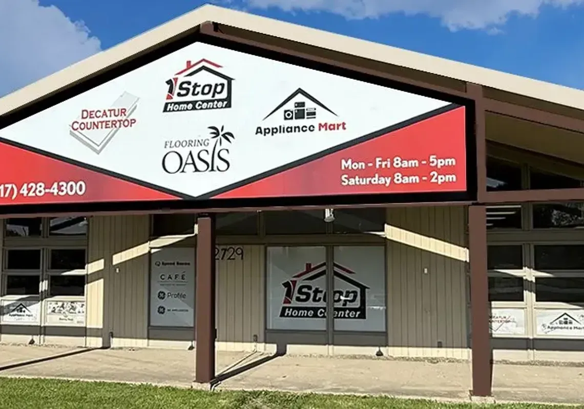 Small roadside building with a red and white front sign reading “Old Oaks,” under a brown roof.