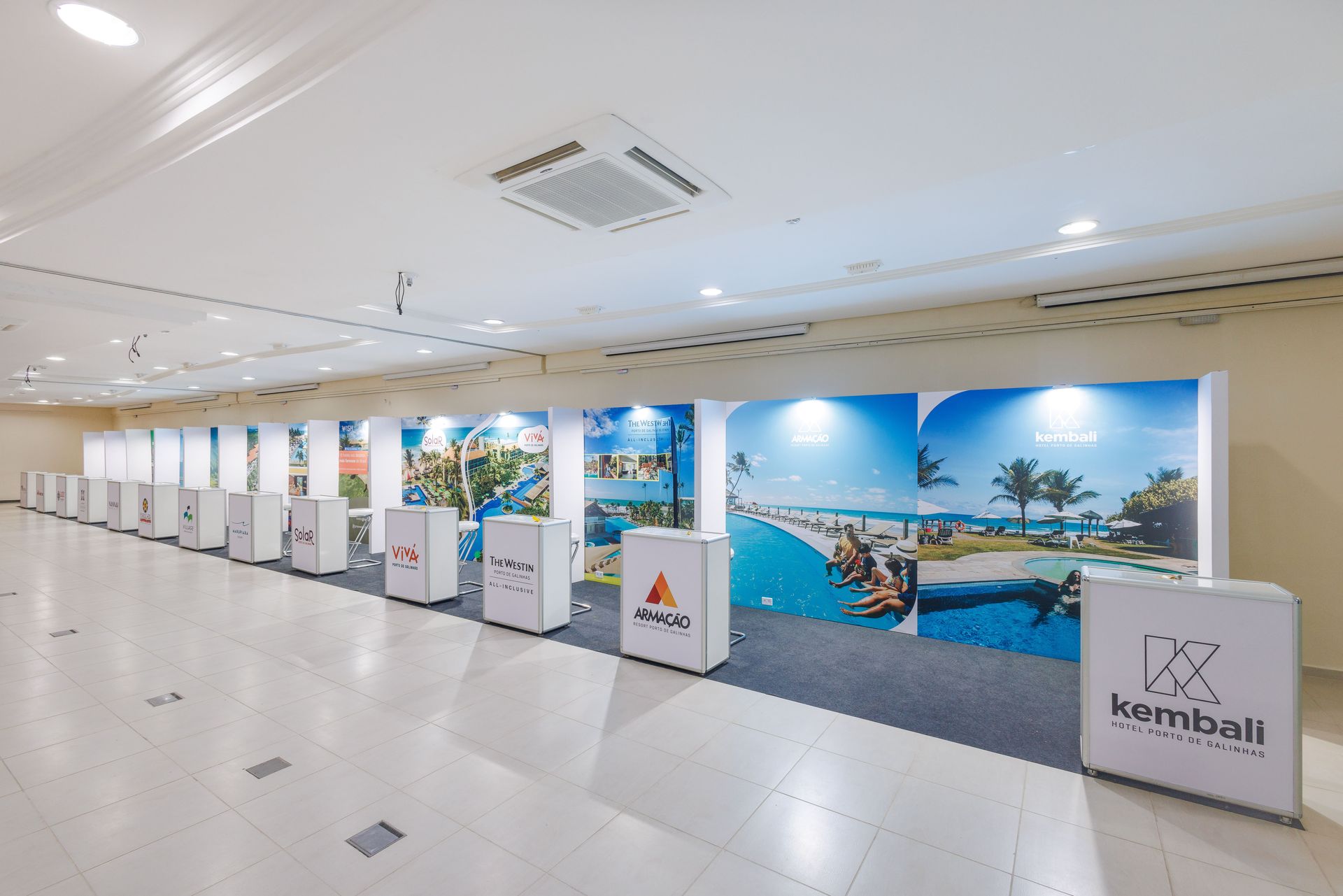corredor com estandes e painéis expositivos em espaço interno de evento