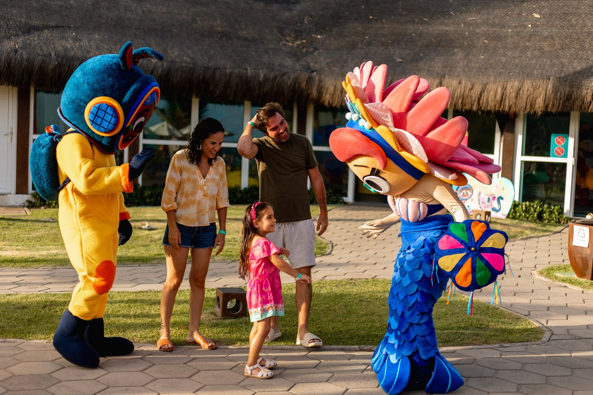 Família se diverte com personagens coloridos no jardim do Armação Resort, experiência infantil em Porto de Galinhas