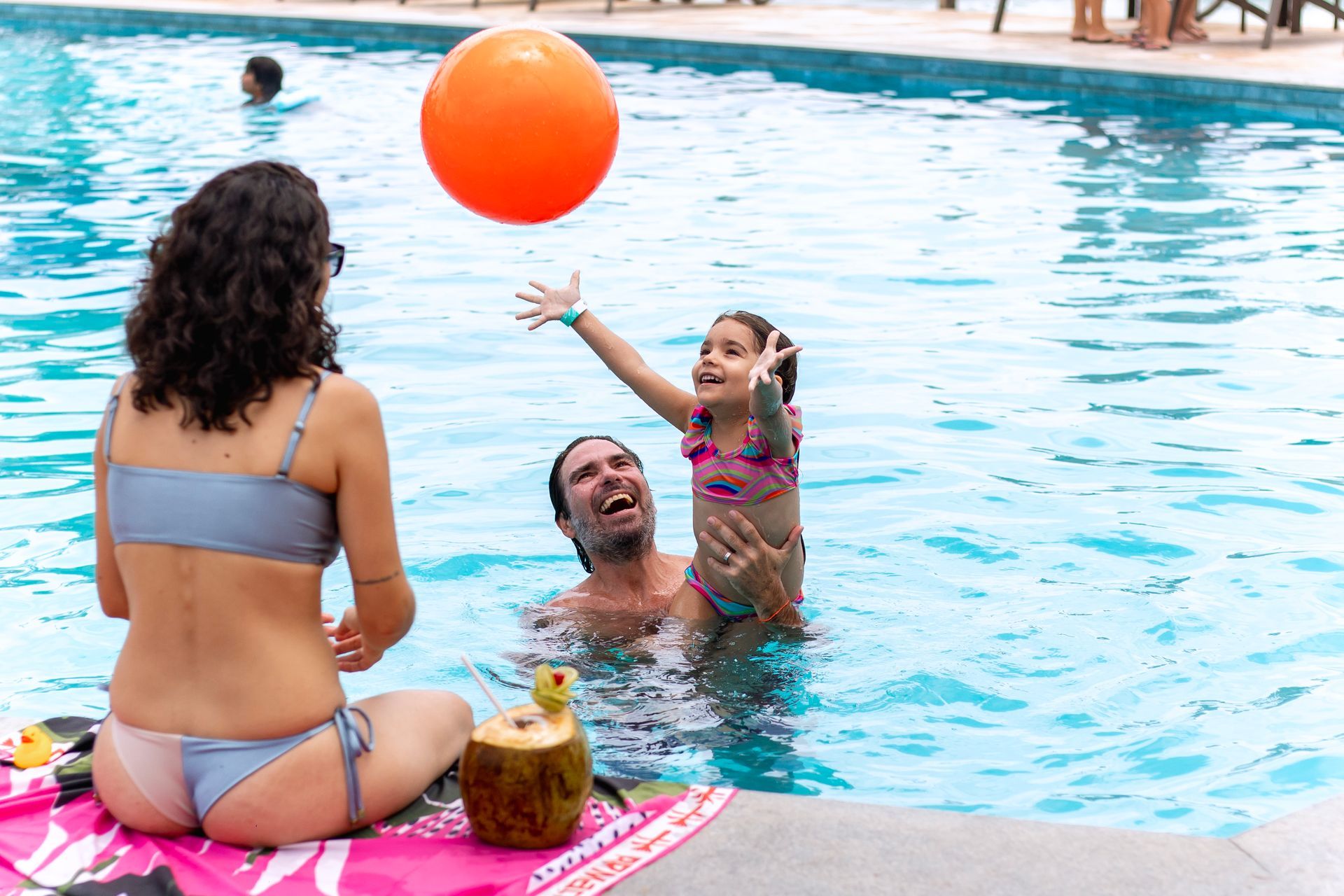 Família brinca na piscina do Armação Resort, aproveitando momentos de diversão e lazer em um dia de sol.