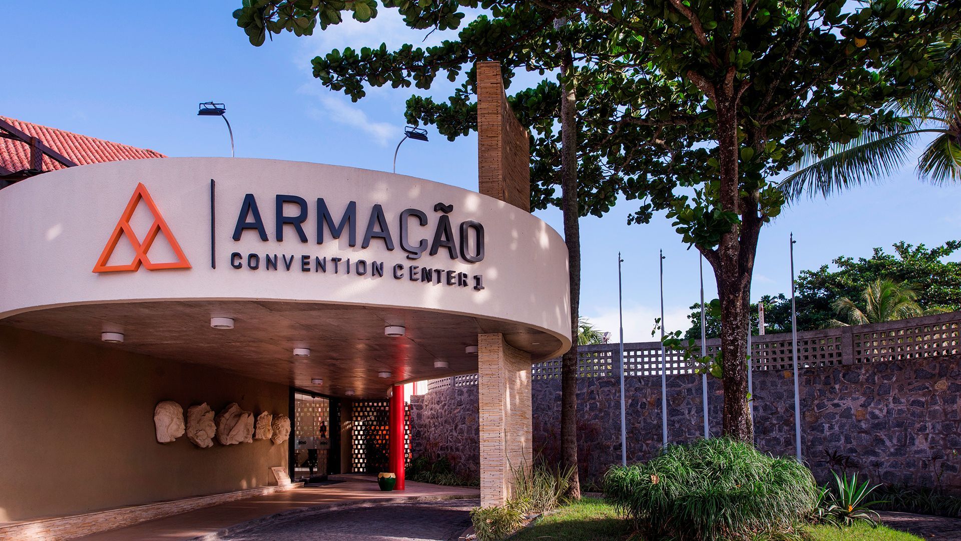 entrada do Armação Convention Center com fachada e sinalização do local. uma árvora está à frente.