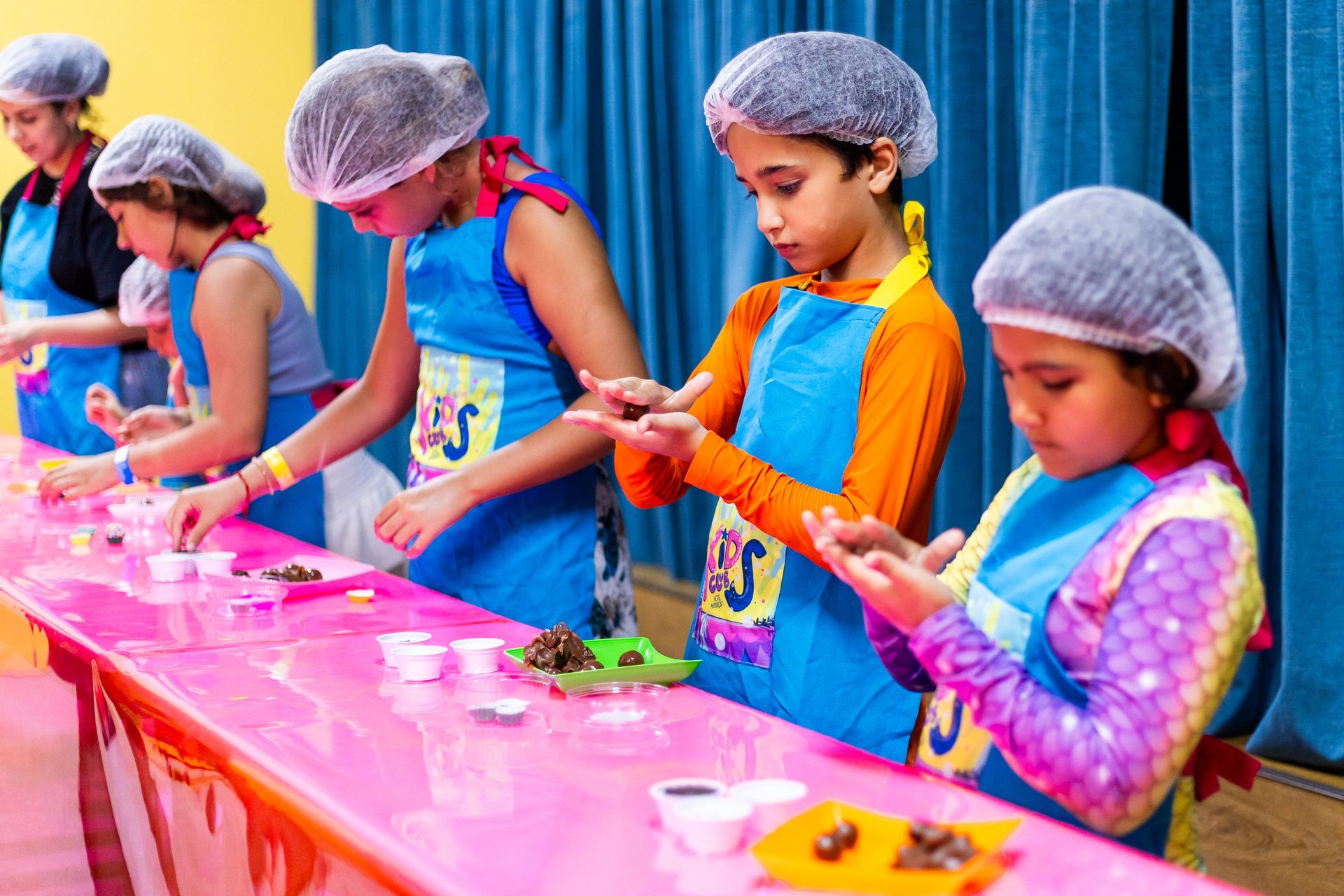 Crianças participam de oficina culinária infantil durante atividade recreativa no Armação Resort.