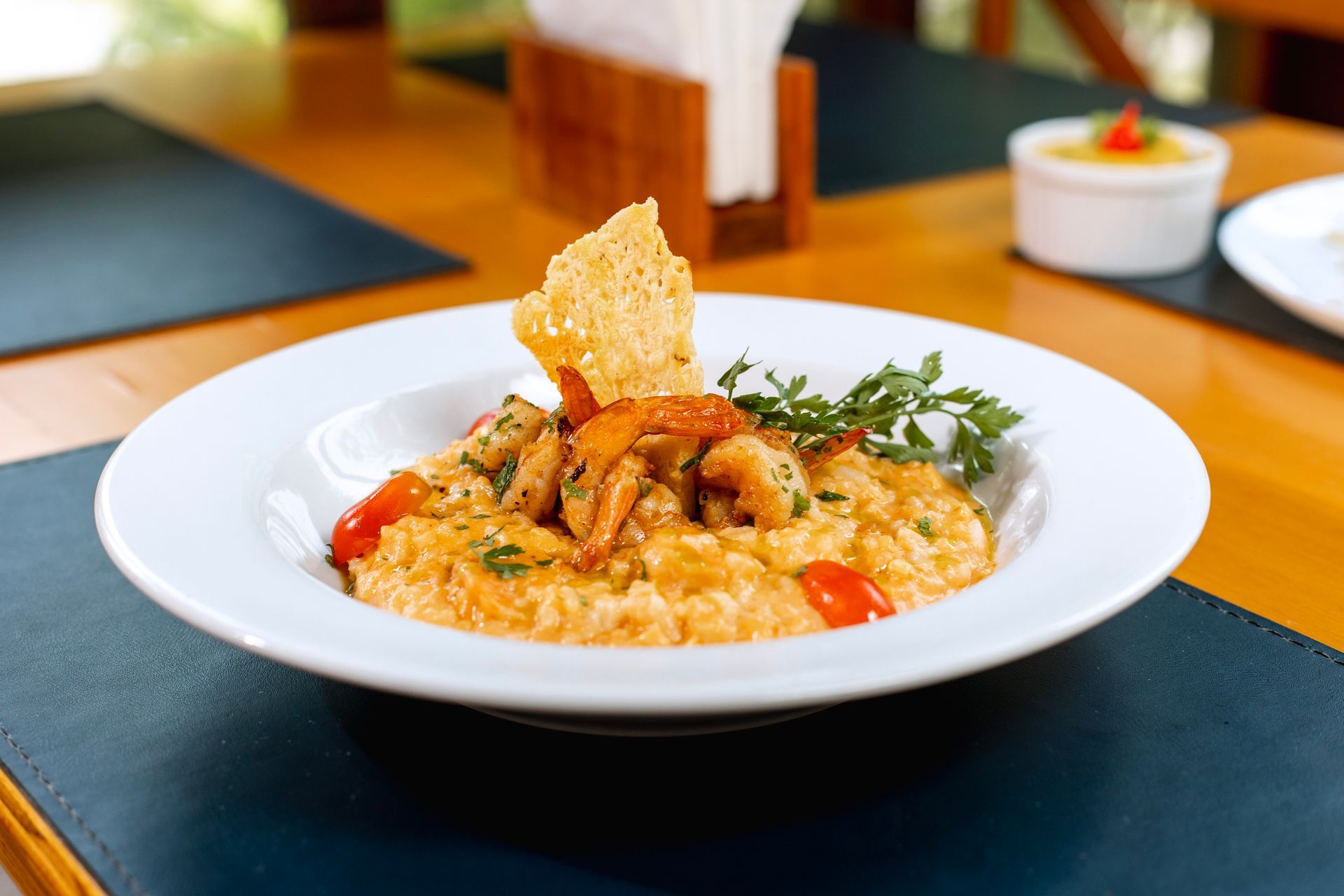Prato de risoto cremoso com camarões servido no Armação Resort, destacando a gastronomia do resort em Porto de Galinhas e a experiência gastronômica durante a estadia.