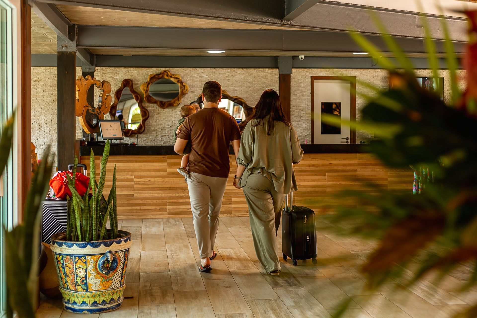 Recepção acolhedora do Armação Resort com plantas, espelhos decorativos e design elegante.