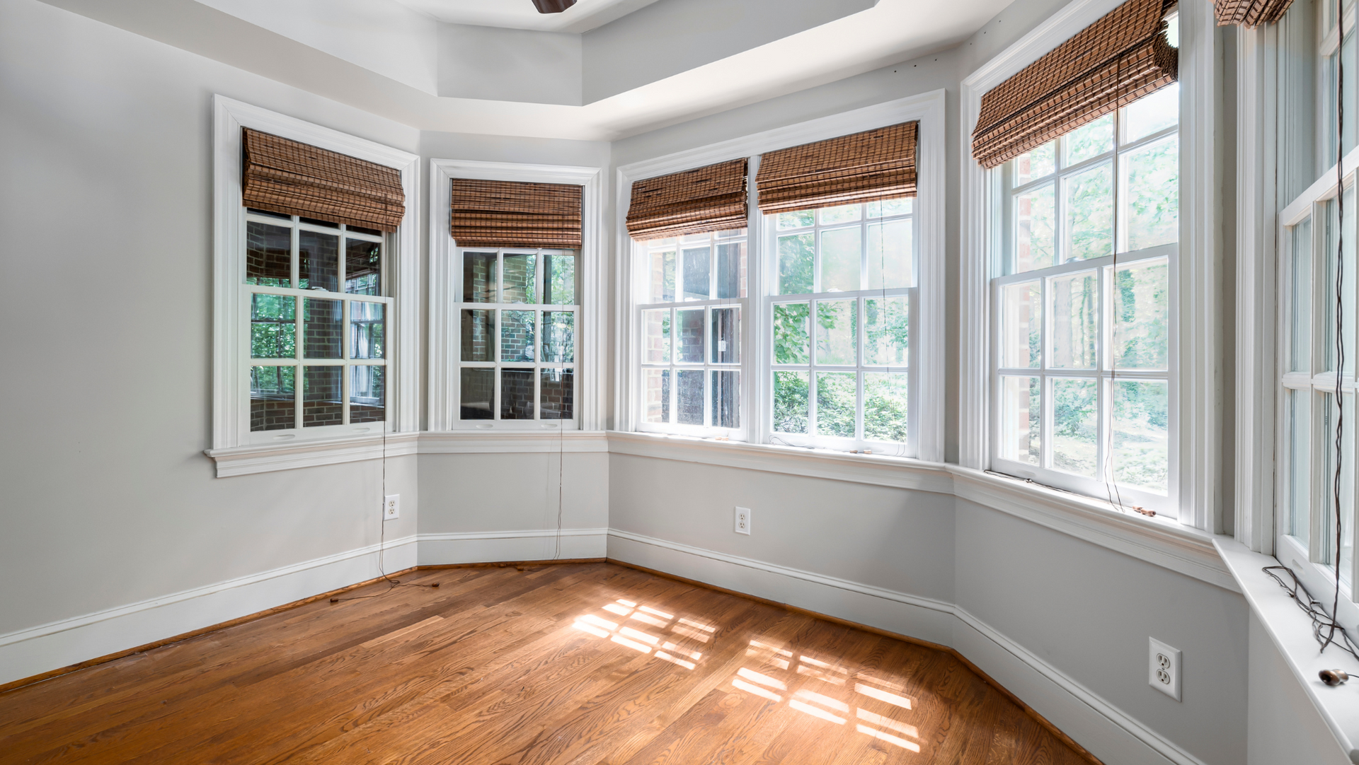 An empty room with hardwood floors and lots of updated windows in Vermont