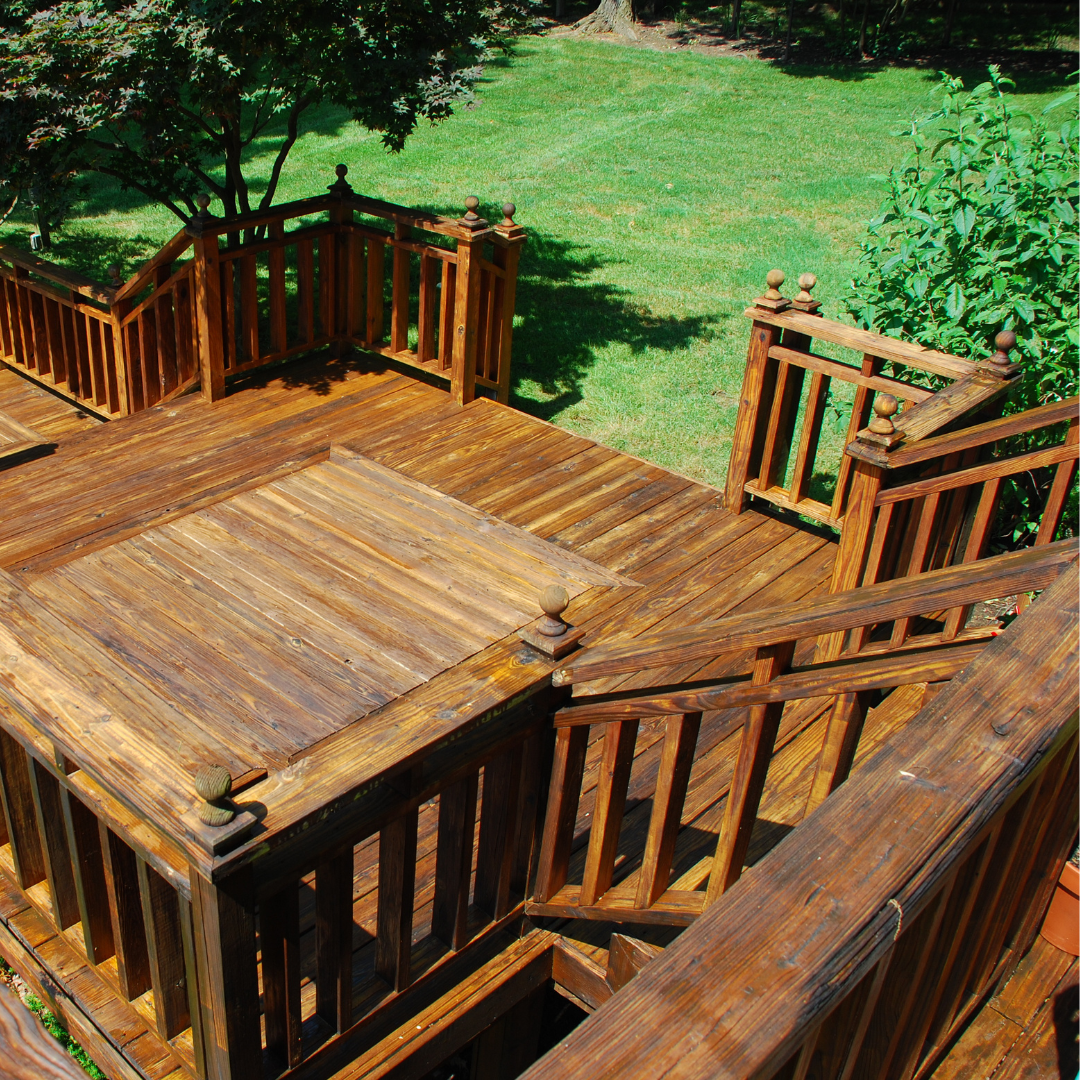 A wooden deck on a Vermont home that leads out to a green lawn