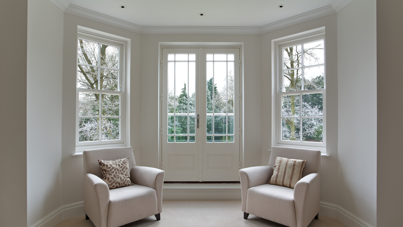 Large windows in the living room of a home in Vermont in the winter.