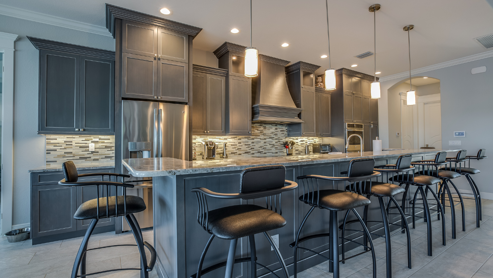 Gray shaker cabinets with a tiled backsplash and a large island in a Vermont kitchen