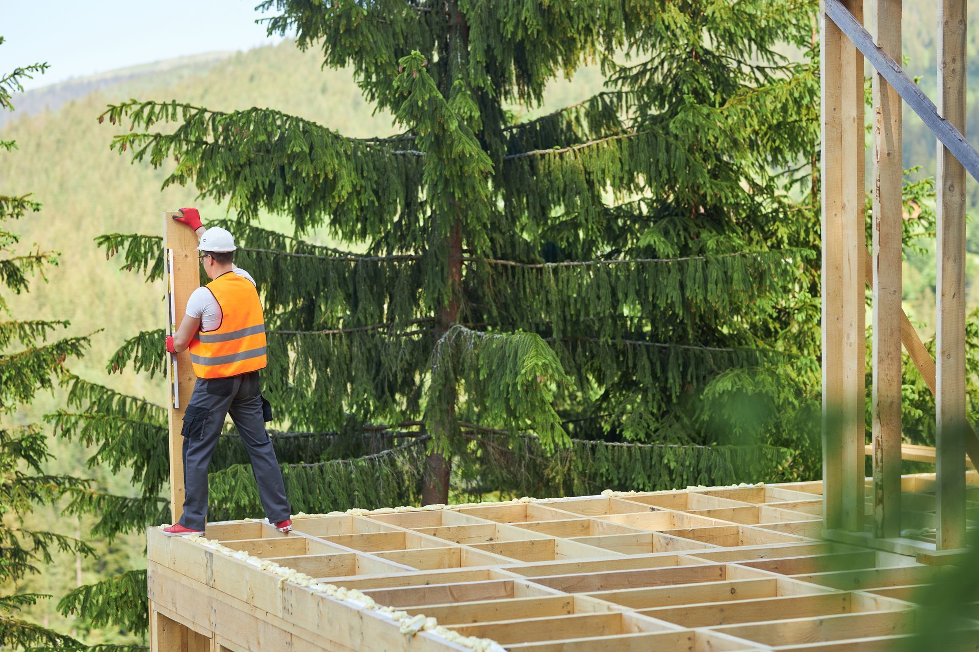 Construction worker framing new home in Vermont during summer building season