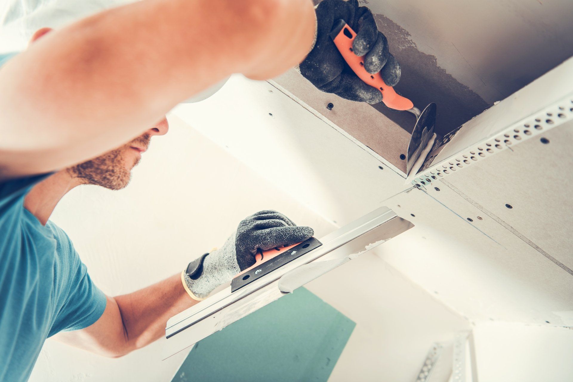 man filling in screw and nails holes in drywalls