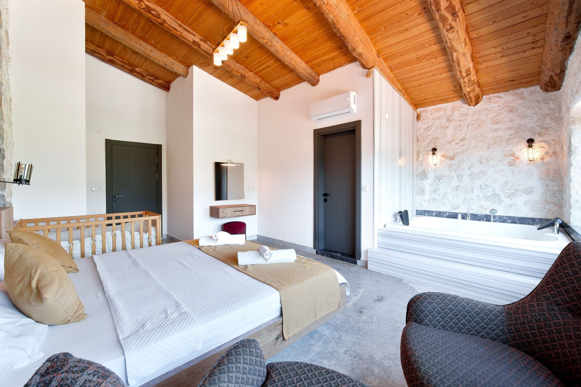 Bright Vermont guest suite with exposed wood ceiling and cozy beds for flexible living.